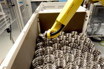 An automated FANUC robot boxes and palletises parts