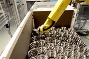 An automated FANUC robot boxes and palletises parts