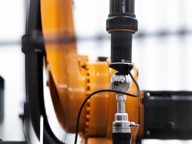 De Renishaw RCS L-90 ballbar voor industriële automatisering aangebracht tussen een robotarm en een kalibratiekogel in een robotcel