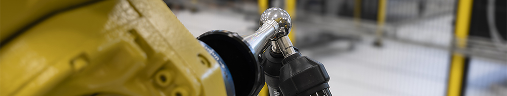 A FANUC six-axis robot in an automation cell using an RCS T-90 tri-ballbar system