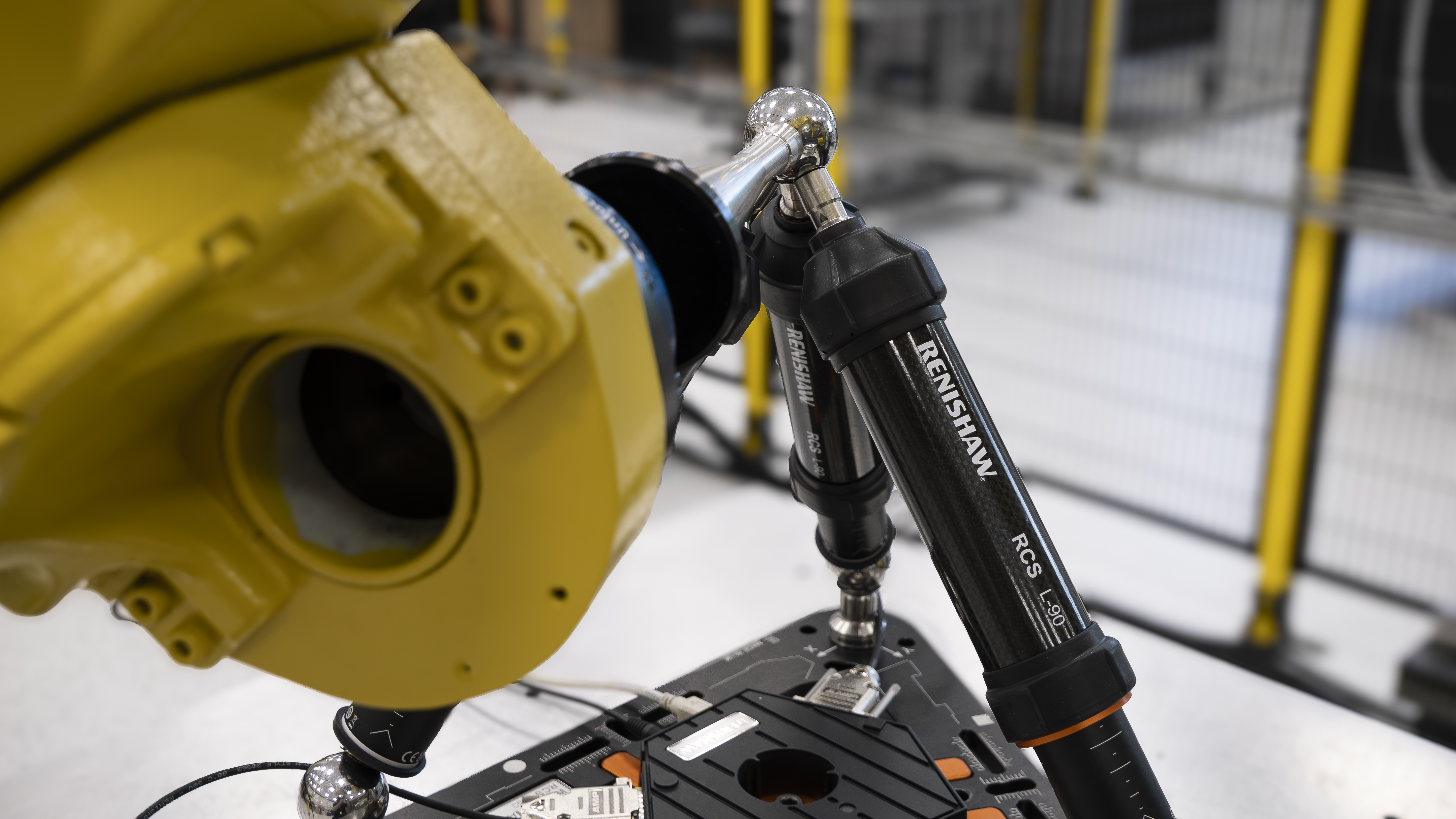 A FANUC six-axis robot in an automation cell using an RCS T-90 tri-ballbar system