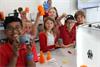 School children with 3D printed parts they produced