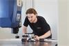 An engineer handling the XL-80 interferometer with optics and using the XC100 for environmental compensation.