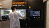 Tronosjet case study 8 - Operator handling the build plate within the chamber of a RenAM 500 Flex.
