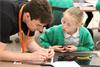 STEM ambassador and girl work on a project